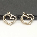Detail showing two golden double-heart pendants with sparkling rhinestones and a smooth finish - One Small Heart / Gold
