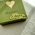 Close-up of golden Merry Christmas acrylic cake topper with festive bells on a gift box - Gold / Oversized / Plus Thick Style