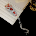 Dettaglio molletta a croce con strass rossi e lunghe nappe argentate su portagioie - Base Grigia Strass Rosso (Clip BB)