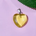 Translucent yellow heart stone pendant with silver clasp on pink background - 54-Glass Light Yellow
