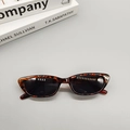 Dettaglio ravvicinato di occhiali da sole cat-eye tartarugati su decorazione minimal - Stampa leopardata