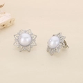 Macro shot of silver sunflower earrings featuring a white pearl and hollow metal petals - Steel Sunflower Pearl Style (KE116427-KFC)