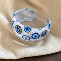 Macro-opname van kleurrijke acryl boze oogpatronen op de brede open bangle armband - Armband Wit met Evil Eye