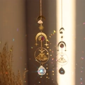 Detailed brass moth suncatcher with pink raw quartz crystal and rainbow light reflections - Bearded Butterfly