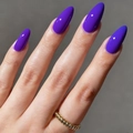 Vue macro d'ongles amande violet foncé brillant avec une bague torsadée dorée - Violet Foncé Brillant (AW293)