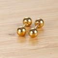 Poliertes Gold Edelstahl Kugelstecker mit Schraubverschluss auf Holz Hintergrund - 4mm Goldfarbe