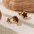 Elegant gold star stud earrings with dark red gemstone inlay on a natural stone background - Red Star Stud Earrings (BD513-red)