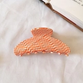 Orange and white checkered acetate hair claw clip on a soft textured fabric - Orange Gingham