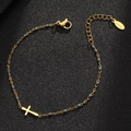 Dettaglio del bracciale dorato in acciaio con croce e perline grigie su sfondo nero opaco - Oro-Grigio