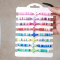 Buntes 8-teiliges Boho-Armband-Set aus Fimo mit Kreuzen auf einem Handdisplay präsentiert - SY0299-1 / 8 Stück Packung
