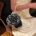 Detailed shot of rose-shaped satin evening bag with pearl handle and metal clasp - Pearl Handle / Black