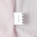 Macro shot of white laundry care label showing 100% cotton fabric and washing icons - S / Pink