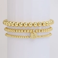 Three-piece set of golden beaded bracelets featuring a round initial A letter pendant tag - Letter A
