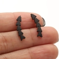 Stud earrings with black geometric arrow pattern in matte finish held on fingers - 676 Fishbone Leaf / Black