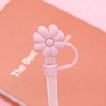 Pink flower shaped silicone straw cover for 10mm tumblers shown on a table - Pink Flower / 10mm
