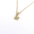 Macro shot of gold initial N pendant showcasing polished metal texture and smooth edges - Letter N