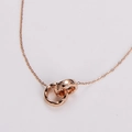Detalle de anillos entrelazados en oro rosa con diseño acolchado en un collar delicado - Oro rosa
