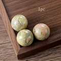 Polished natural green jasper crystal sphere shown in a rustic wooden display tray - Unakite