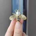 Golden bee brooch with white crystals, black stones, and a large central pearl detail - Gold Bee-White Pearl (XZ0191)