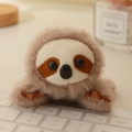 Schattige luiaard knuffelmagneet in bruin op een wit minimalistisch toetsenbord - Luiaard