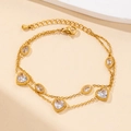 Detail of a double-layered gold bracelet with heart and oval zircon crystals and lobster clasp - Double Layer Oval Clear Zircon