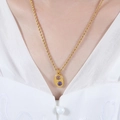 Goldene Kordelkette mit ovalem Anhänger und pinkfarbenen sowie lila Edelsteinen - Halskette / Gold