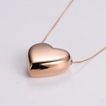 Macro shot of 3D heart pendant necklace with polished rose gold finish on snake chain - Large / Rose Gold