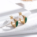 Orecchini vintage a C dorati con zircone verde smeraldo su sfondo di pietra bianca naturale - Verde