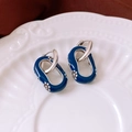 Dettaglio di orecchini ovali in smalto blu con motivi floreali su vassoio bianco - Blu/Argento