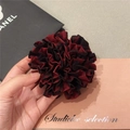 Detalle de un accesorio de flor en tela burdeos que muestra la textura del tejido - Pequeño / Rojo/Negro a Cuadros