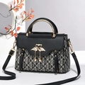 Elegant black monogram flap bag with golden handle and swan clasp on a neutral background - Black