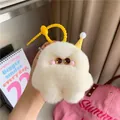 Gros plan d'un porte-clés monstre en peluche blanche avec des yeux étoilés - Blanc Cassé