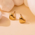 Macro shot of minimalist gold heart stud earrings on white natural pebbles texture - Gold Heart Studs