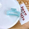 Matte mint blue rectangular hollow hair claw clip displayed on a white ceramic plate - Jelly Blue