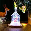 Close-up of a lit Christmas church snow globe with Santa Claus on a rustic wooden base - Santa Claus