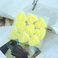 Set mit 9 herzförmigen Duftkerzen in Zitronengelb in dekorativer PVC-Geschenkbox - 9er Set / Gelb