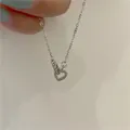 Silver double-layered necklace featuring hollow heart pendant and small sparkling ring - Interlocking Hearts Style