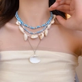 Detalle del collar bohemio de varias capas con cuentas azules y colgantes de concha en modelo - Juego de 4 Collares de Conchas