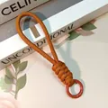 Hand-woven orange and brown knotted phone lanyard with a red metal ring buckle - Brown