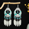 Bohemian silver earrings with turquoise beads and feather tassel charms on wood - Blue