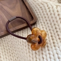 Detail of amber resin flower charm on a high-elastic brown hair tie with a wood background - Amber Flower / Brown