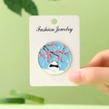 Cute panda and cherry blossom enamel pin brooch on a 3.5cm round blue metal badge - Panda Under Cherry Blossoms