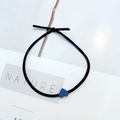 Detailopname van zwarte elastische haarband met een blauwe hartvormige hanger op wit - Koningsblauw Hart