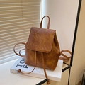 Minimalist vintage brown faux leather backpack with drawstring closure on a cozy windowsill - Brown