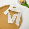 Elegant white velvet hair clip with long ribbons on a decorative cork tray - White