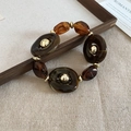 Bracciale artistico in acrilico e resina ambra con anelli e perle di metallo dorato - Bracciale - Caffè Scuro
