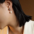 Elegante witte zoetwaterparel oorbellen met zilveren bolletje gedragen door een model - Zilver