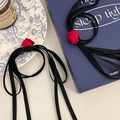 Gros plan détaillé d'une rose en satin rouge avec de longs rubans noirs élégants - Élastique à cheveux / Ruban noir rose rouge