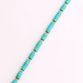 Détail macro du collier en titane plaqué or avec perles turquoise sur fond blanc pur - Bleu lac