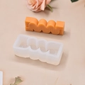 Detailansicht der S-förmigen geometrischen Silikonform mit fertiger orangefarbener Kerze - Klein